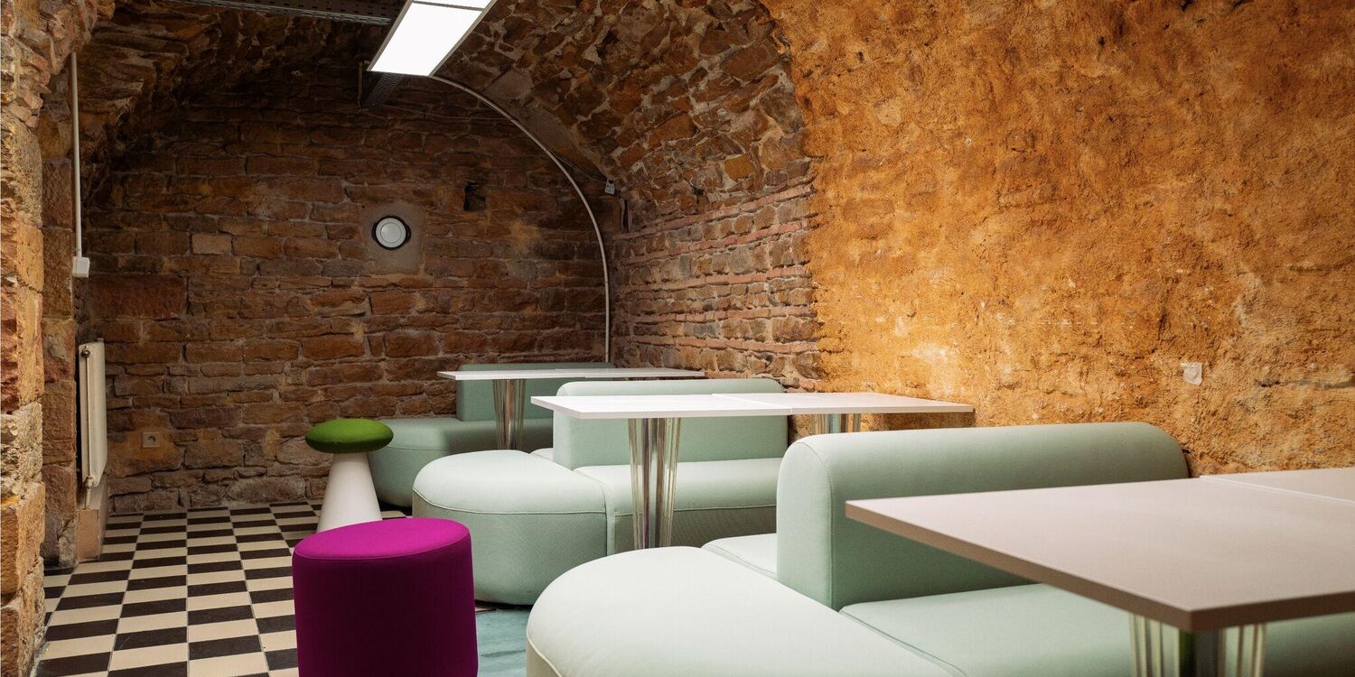 La cave voûtée d'UFO, murs de pierre et banquettes vert d'eau